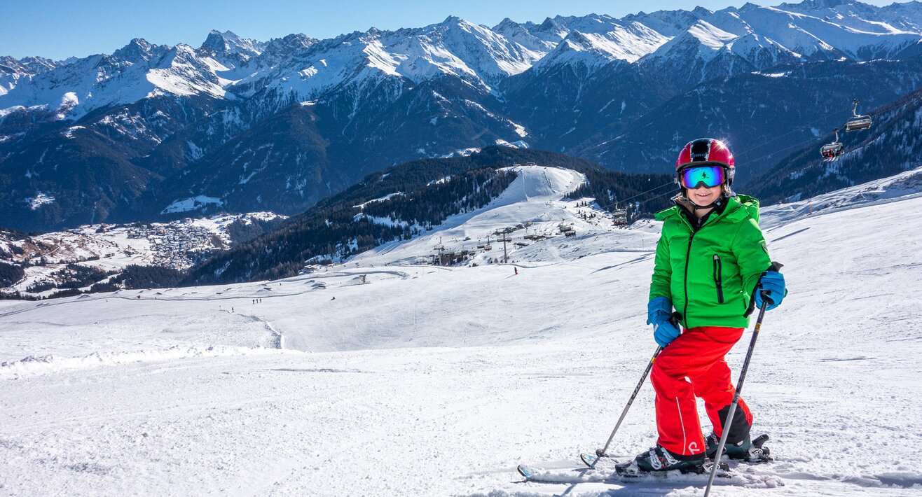 Skifahrer auf einer breiten Piste in der Familienregion Serfaus-Fiss-Ladis in Tirol mit Blick auf Alpkopf und Komperdell | © Patotra