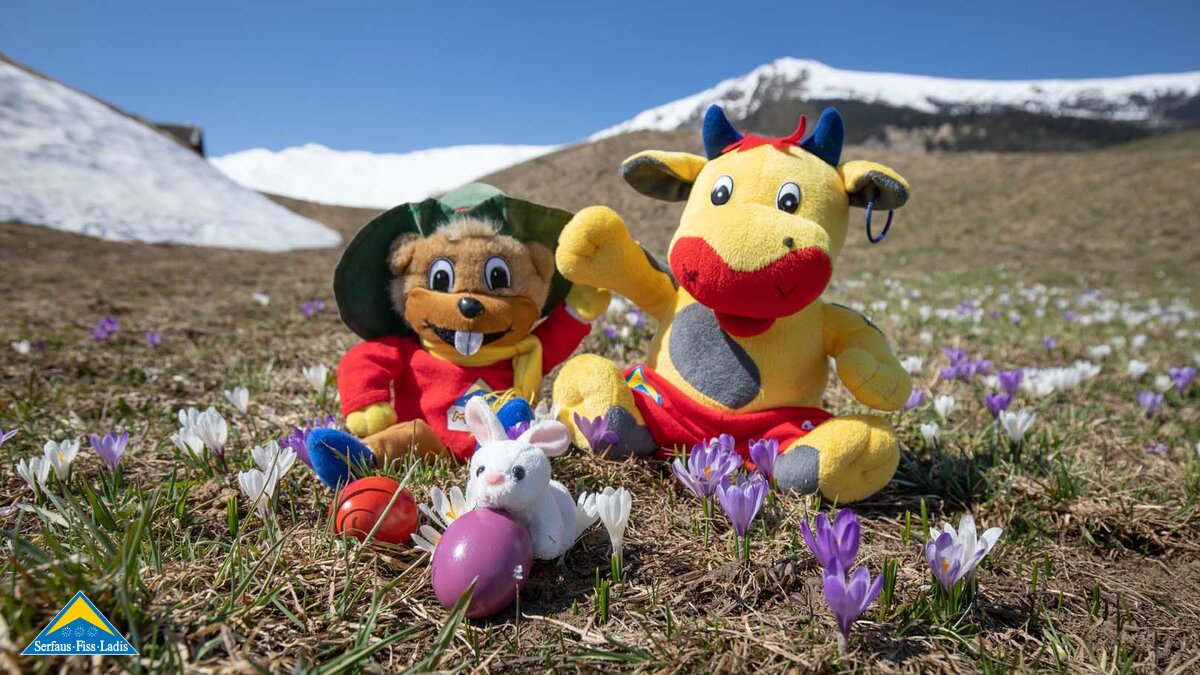 Stofftiere Murmli und Berta Maskottchen der Familienregion Serfaus-Fiss-Ladis frühlingshafter Hintergrund mit Krokussen und Ostereiern | © Serfaus-Fiss-Ladis Marketing GmbH | Andreas Kirschner