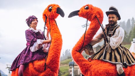 Kostüm mit orangen Vögeln Showeinlage beim Erlebnisabend Fiss  | © Spielvolk