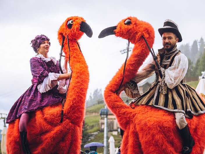 Kostüm mit orangen Vögeln Showeinlage beim Erlebnisabend Fiss  | © Spielvolk