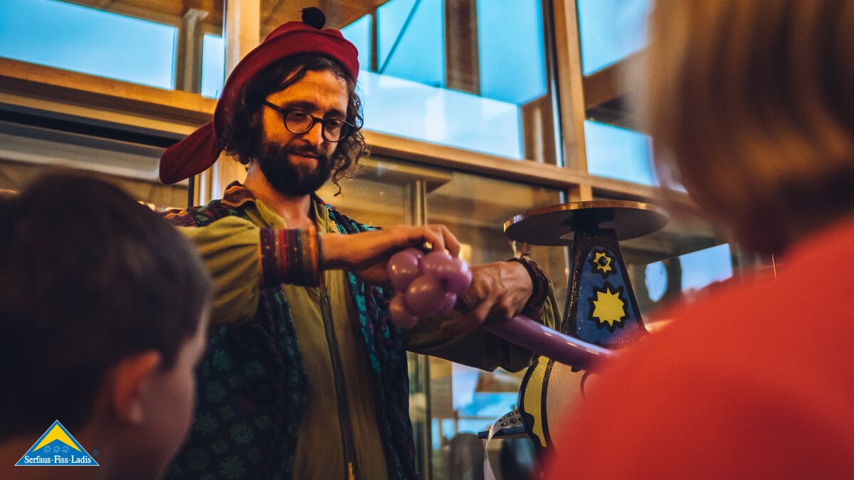 Zauberkünstler beim Modellieren eines Luftballons Erlebnisabend Fiss Familienurlaub in Serfaus-Fiss-Ladis in Tirol | © Spielvolk