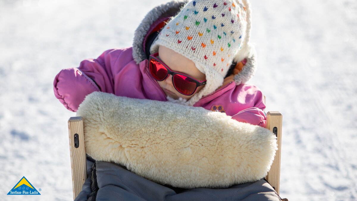 Kleinkind auf Rodel mit Fellsack Winterwandern mit kleinen Kindern in Serfaus-Fiss-Ladis | © Serfaus-Fiss-Ladis Marketing GmbH | Andreas Kirschner