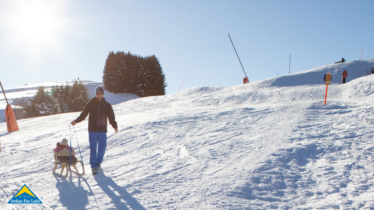 Pistenquerung Winterwanderer mit Kleinkind auf Rodel sitzend Winterwandern in Serfaus-Fiss-Ladis | © Serfaus-Fiss-Ladis Marketing GmbH | Andreas Kirschner
