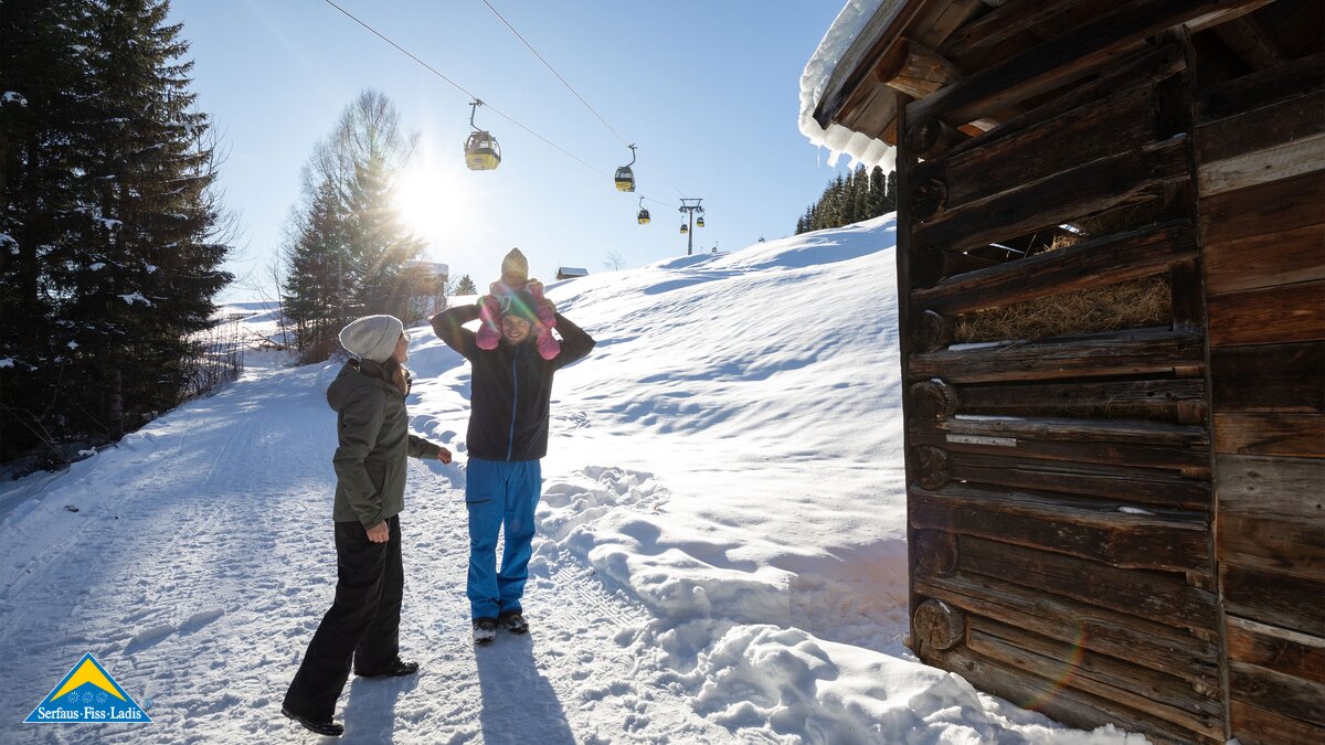 Winterwanderweg Trasse der Sonnenbahn Kleindkind sitzt auf Schulter in der Familienregion Serfaus-Fiss-Ladis in Tirol | © Serfaus-Fiss-Ladis Marketing GmbH | Andreas Kirschner