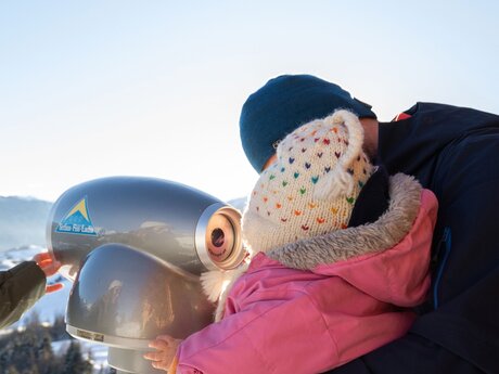 Kind blickt durchs Fernrohr Wolffühlstation Falterjöchl Winterurlaub in Serfaus-Fiss-Ladis in Tirol | © Serfaus-Fiss-Ladis Marketing GmbH | Andreas Kirschner