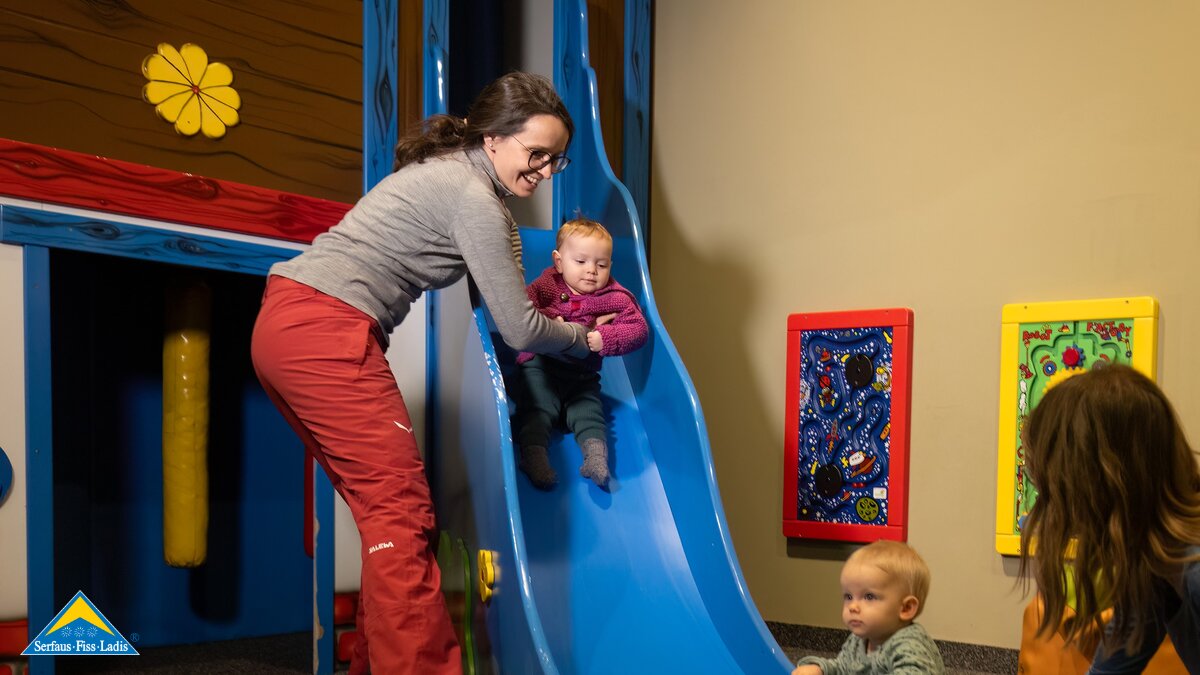 Mama rutscht mit Kleinkind auf einer Rutsche herunter Spielplatz für Kleinkinder Tipps Winterurlaub Serfaus-Fiss-Ladis Blog | © Serfaus-Fiss-Ladis Marketing GmbH | Andreas Kirschner