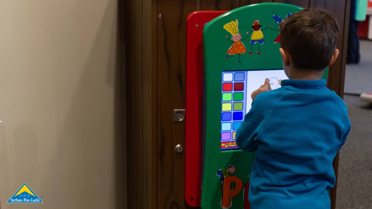 Junge malt am Bildschirm Spielplatz im Komfort-Skidepot Tipp Alternative zum Skifahren Winterurlaub mit Kleinkindern in Serfaus-Fiss-Ladis in Tirol | © Serfaus-Fiss-Ladis Marketing GmbH | Andreas Kirschner