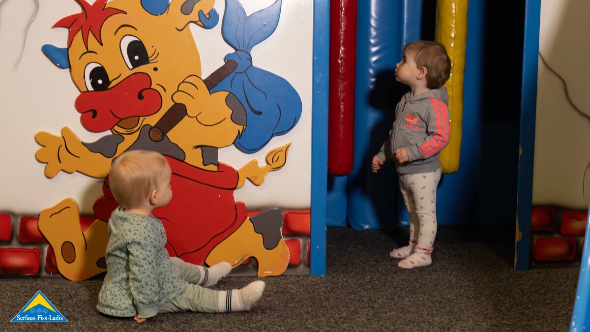 zwei Kleinkinder spielen im Indoor Spielplatz an der Talstation in Fiss Familienregion Serfaus-Fiss-Ladis Tirol Maskottchen Berta | © Serfaus-Fiss-Ladis Marketing GmbH | Andreas Kirschner