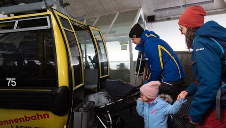 Helping Hands Liftpersonal hilft beim Einsteigen in die Gondel der Sonnenbahn mit Kinderwagen Serafaus-Fiss-Ladis in Tirol | © Serfaus-Fiss-Ladis Marketing GmbH | Andreas Kirschner