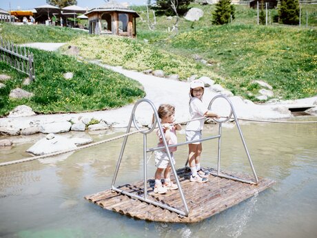 Kinder fahren auf einem Floß im Murmliwasser Serfaus | ©  Serfaus-Fiss-Ladis Marketing GmbH | Rene Raggl