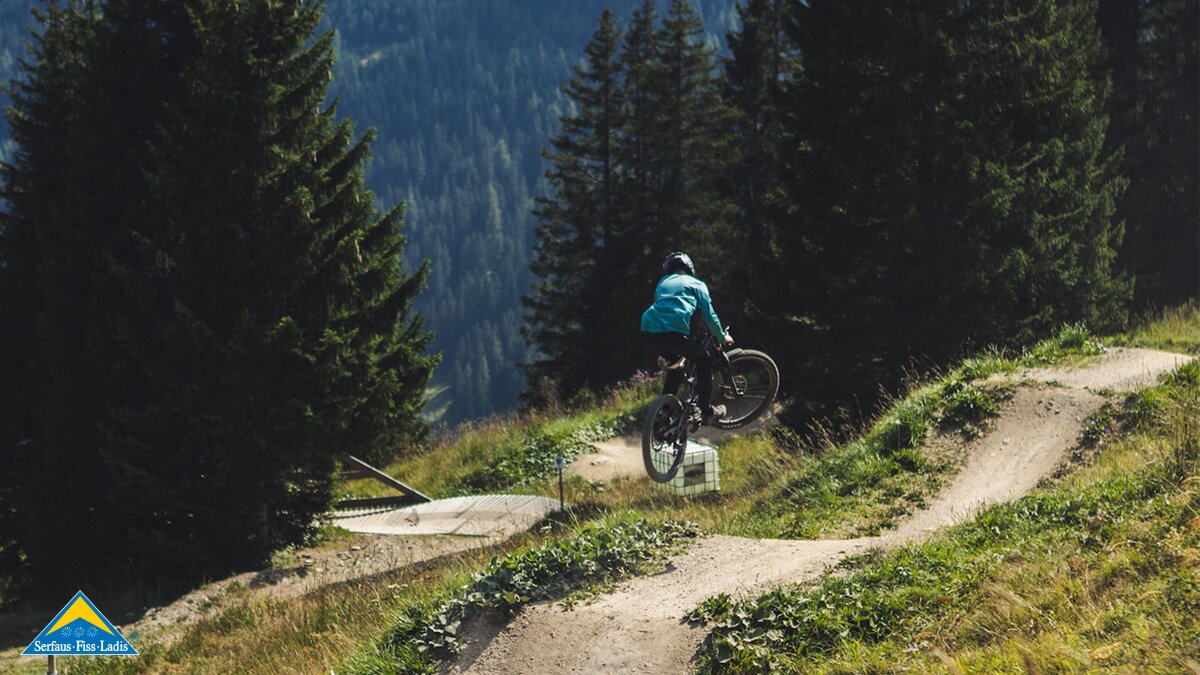 Downhiller beim Springen in Tirol | © Serfaus-Fiss-Ladis Marketing GmbH | Marius Schatz, Roadtyping